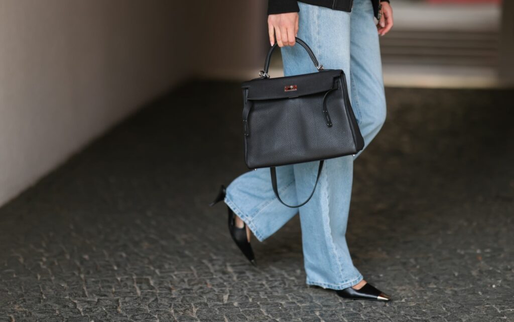 boty k širokým kalhotám - modelka v širokých džínách a černých jehlových lodičkách s kovovou špičkou