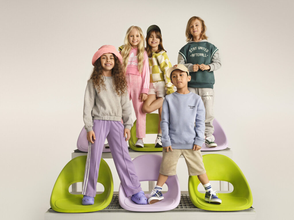 5 dětských modelů pózujících na barevných židlích