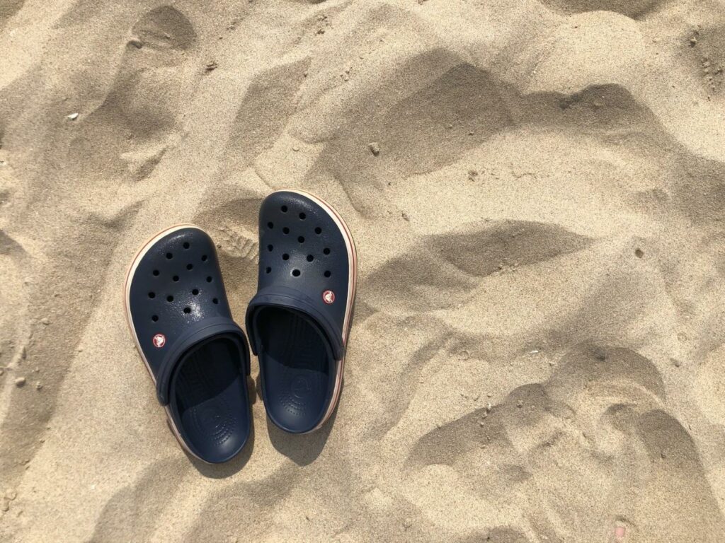 Námořnicky modré boty Crocs na pláži