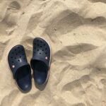 Námořnicky modré boty Crocs na pláži