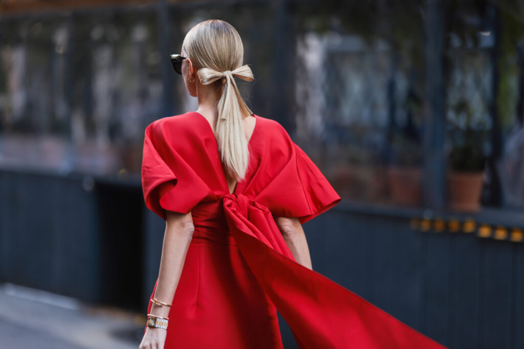 jak se obléknout na Vánoce 2023 – žena v elegantních dlouhých červených šatech s mašlí vzadu