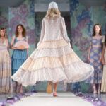 Trendy 2024: módní šaty pro jaro 2024 – v popředí modelka v rozevlátých vzdušných šatech s květinovým motivem