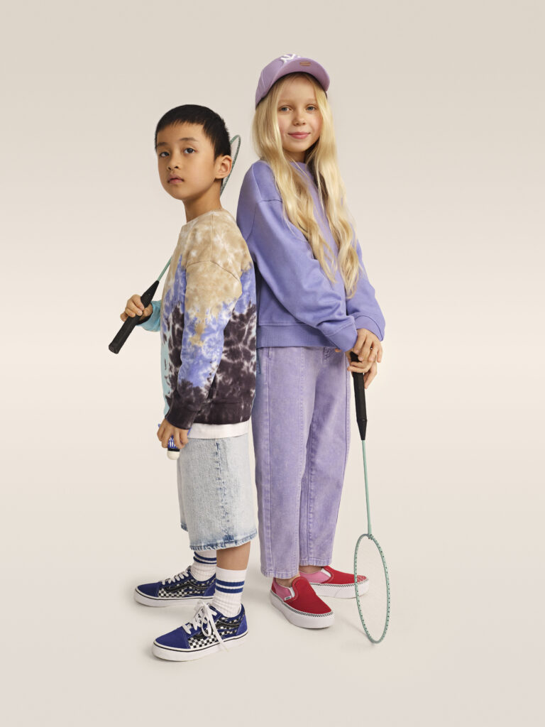 Chlapec a dívka v outfitech fialové barvy, v teniskách Vans.
