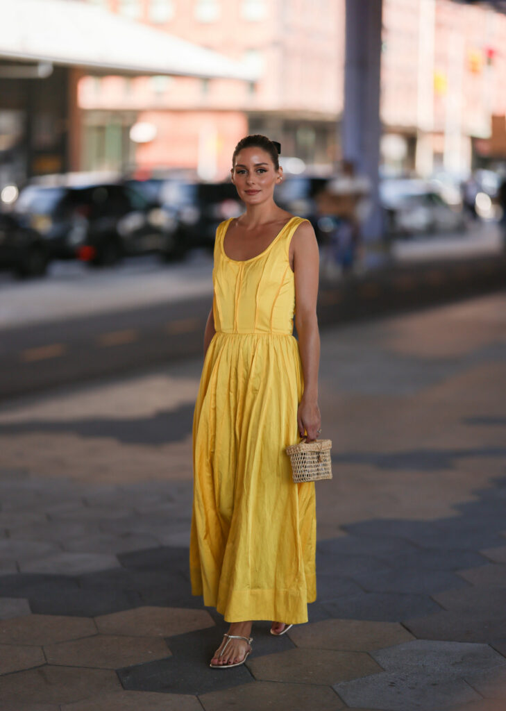  Žena ve žlutých maxi šatech a stříbrných sandálech
