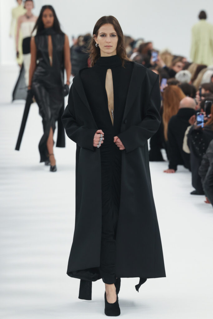 modelka na přehlídkovém mole Givenchy v módním dámském kabátu