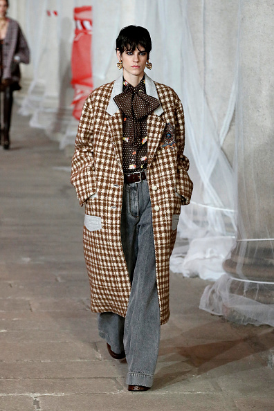 modelka na přehlídkovém molu Etro v kostkovaném kabátu a širokých kalhotách
