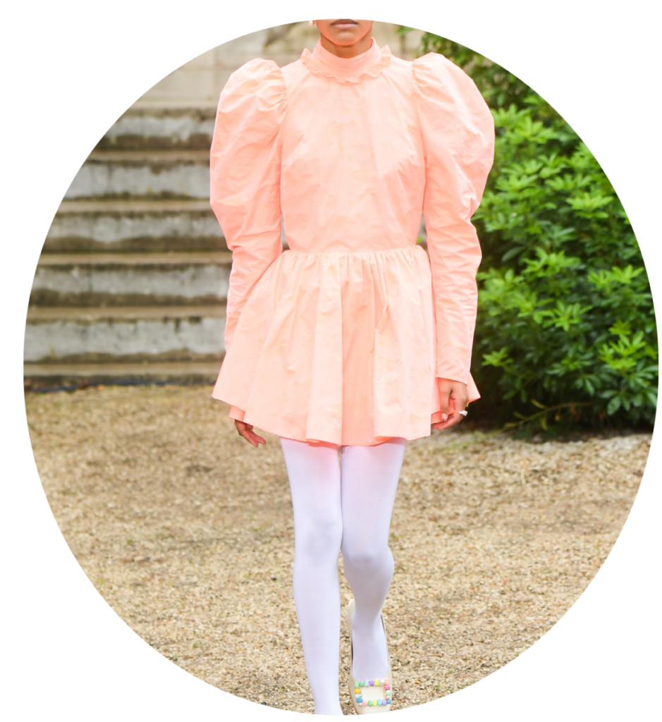 Barva roku Pantone 2024: broskvové chlupaté šaty, bílé punčocháče a boty s ozdobnou barevnou sponou