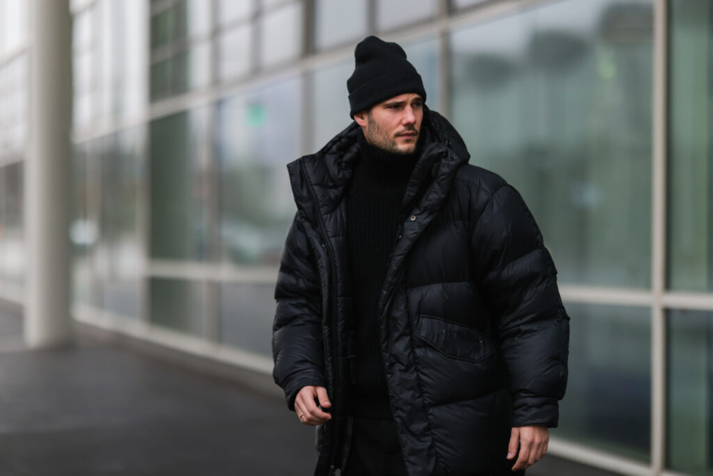 Muž v černé pánské péřové bundě, stylizace black total look